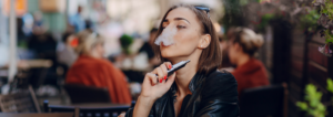 Femme qui fume une cigarette électronique dans un bar